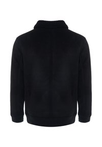 Juoda zomšos oda striukė su minkštu kailinėliu apykaklėje, apsiūtais rankogaliais ir apačia, bei lygiu paviršiumi. Turi tvarkingą, aptakų nugaros dizainą.