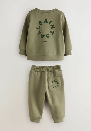 Olivově zelená mikina a souprava tepláků. Mikina má výrazný kulatý text a žebrované manžety. Tepláky mají elastický pas a zadní kapsu.