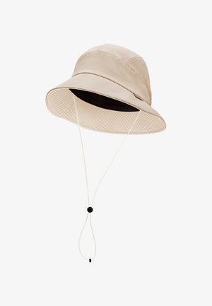 Chapeau seau beige avec un large bord doublé de mesh et une sangle de menton ajustable équipée d'un verrou noir.