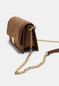 Sac à bandoulière en suède brun avec un rabat arrondi, une chaîne en or et un accent en métal rectangulaire à l'avant. Surface texturée avec des détails de couture.