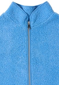 Veste polaire bleu clair avec une fermeture éclair argentée et un col montant, montrant une surface de tissu texturée et bouclée.