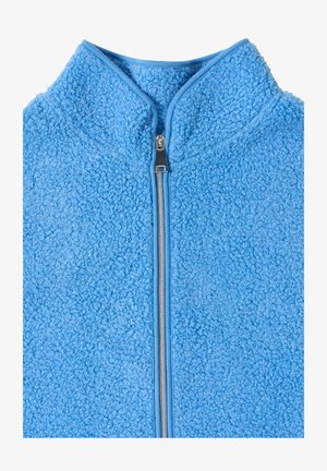 Veste polaire bleu clair avec une fermeture éclair argentée et un col montant, montrant une surface de tissu texturée et bouclée.