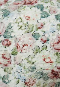 Bloemige kantstof met ingewikkelde patronen in tinten roze, rood, groen en blauw op een lichte achtergrond. Gevoerd met delicate borduursels.