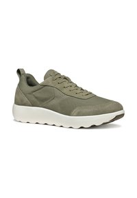 Zapatilla verde oliva con una mezcla de ante suave y malla, con forma de punta redonda y suela blanca acolchada. Con un detalle en forma de pestaña en la parte trasera.