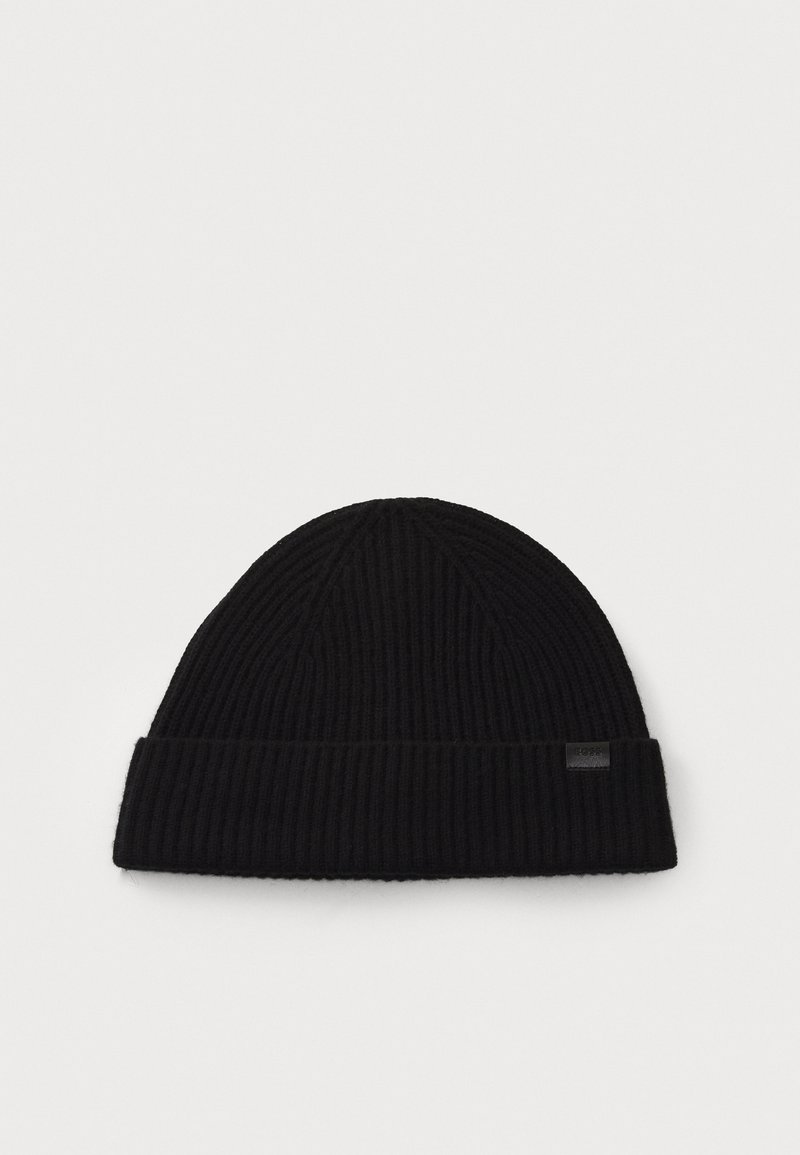 Black ribbed knit beanie with a folded cuff and a small rectangular label on the side. Soft texture, rounded top, and simple design.