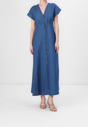 Denim maxi šaty s krátkými rukávy, hlubokým výstřihem do V, předním zapínáním na knoflíky a uvolněným střihem. Jednoduchá modrá barva s jemnou texturou.