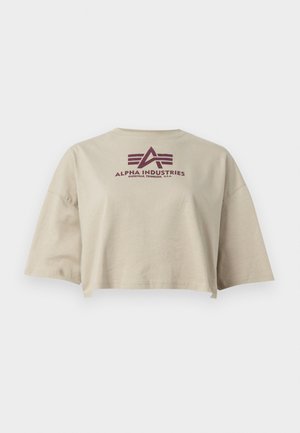 Béžové skrátené tričko vyrobené z bavlny, s krátkymi rukávmi a okrúhlym výstrihom. Na chrbte má bordový logo "Alpha Industries".