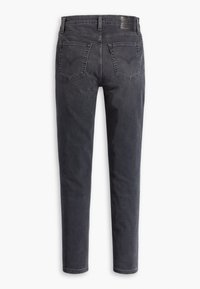 Jeans de mezclilla gris oscuro con un corte ajustado. Las características incluyen dos bolsillos traseros, pasadores para cinturón y un parche de cuero en la parte posterior de la cintura.