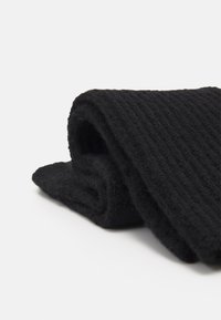 Schwarzer, gerippter Schal mit weicher Textur, ordentlich gefaltet und zeigt ein dickes, gestricktes Design. Keine sichtbaren Muster oder Hardware.