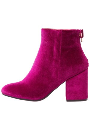 Enkellaars van fuchsia fluweel met blokhak en zijrits, linkerzijaanzicht weergegeven tegen een witte achtergrond.