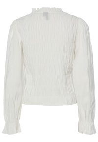 Blusa branca de mangas compridas com textura franzida, decote com frufrus e punhos largos. Tecido suave com um brilho subtil.