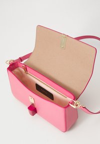 Pink leather handbag with a textured finish, gold hardware, a zip pocket inside, and a magnetic clasp closure; includes a shoulder strap.