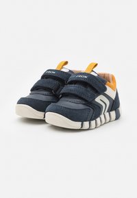 Scarpe per bambini blu navy realizzate in suede e materiale sintetico, dotate di due strap in Velcro, suola in gomma e dettagli gialli.
