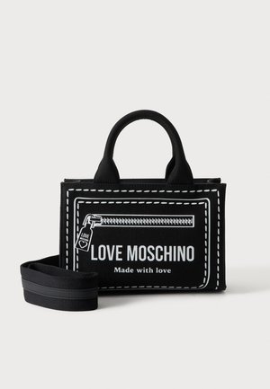 Sac à main Moschino Black Love avec deux poignées, une bandoulière amovible, et une fermeture éclair blanche imprimée avec texte "Made with love."