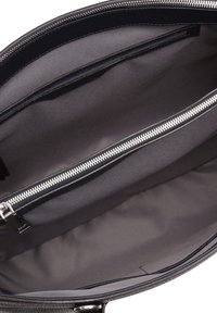 Schwarze Lederhandtasche mit einem glatten grauen Innenfutter, das über ein zentrales Reißverschlussfach und offene Fächer zur Organisation verfügt.