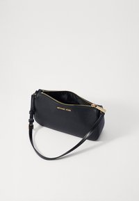 Sort clutch i læder med guld lynlås og beslag. Har en justerbar strop og en tekstureret overflade. Mærkets logo er præget på forsiden.