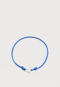 Μπλε ρυθμιζόμενο βραχιόλι με κορδόνι, με ασημένιο δαχτυλίδι και αγκράφα, σε απλό ανοιχτόχρωμο φόντο.