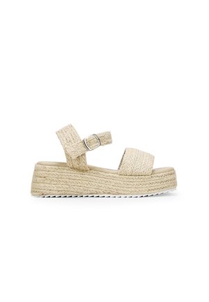 Beige flettede platform-sandaler med to justerbare remme og en spænde. Tekstureret jute-lignende sål med en hvid gummibund.