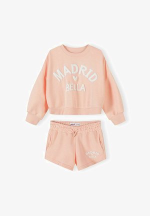 Sweat-shirt court couleur pêche avec le texte "Madrid Bella" et shorts assortis à taille élastique avec cordon de serrage et poches latérales.