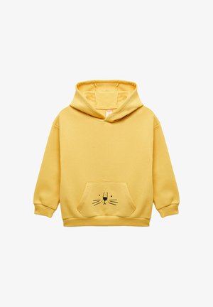 Felpa gialla realizzata in tessuto morbido, con tasca a marsupio e un design di faccia di gatto nero sulla parte anteriore. Stile classico con cappuccio.