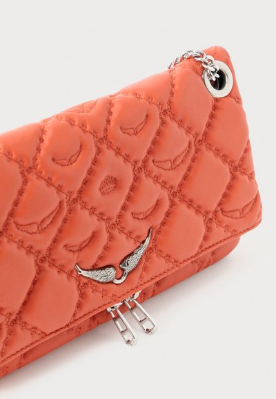 Quiltet orange læder clutch med sølvvingedesign og lynlåsdetaljer. Kompakt, rektangulær form med en tekstureret overflade.