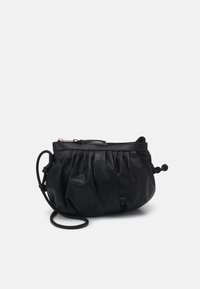 Borsa nera in pelle con un design arricciato, forma curva e chiusura con zip. Presenta una tracolla removibile e dettagli arrotondati. Texture liscia.