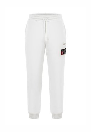 Pantaloni da tuta bianchi realizzati in tessuto morbido. Caratterizzati da un elastico in vita con cordino, polsini a coste e un'etichetta decorativa di lato.