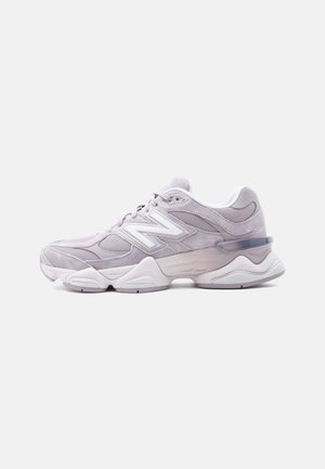 Lyse lilla New Balance sneaker med mesh- og ruskinds-paneler, hvid sål og stort "N" logo på siden, vist fra ydersiden.