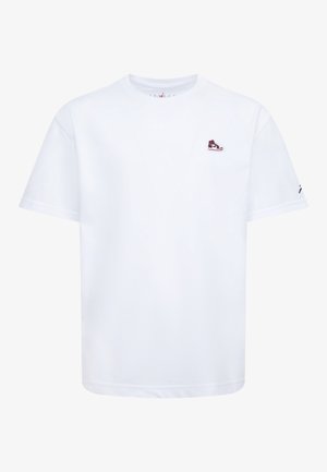 Weißes kurzärmeliges T-Shirt mit kleinem rotem und schwarzem Sneaker-Emblem auf der linken Brust und dezentem Logo am rechten Ärmel.