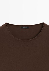 T-shirt marron à col rond avec une étiquette noire visible à l'intérieur du col indiquant "Massimo Dutti Made in China."