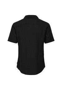 Camisa de manga corta negra hecha de tejido texturizado, con cuello puntiagudo y bajo curvado. Sin patrones visibles ni detalles de hardware.