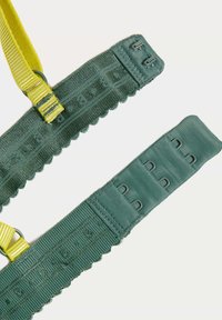 Two fabric straps in varying shades of green with yellow accents. Textured surfaces with adjustable features and strong metal hardware.