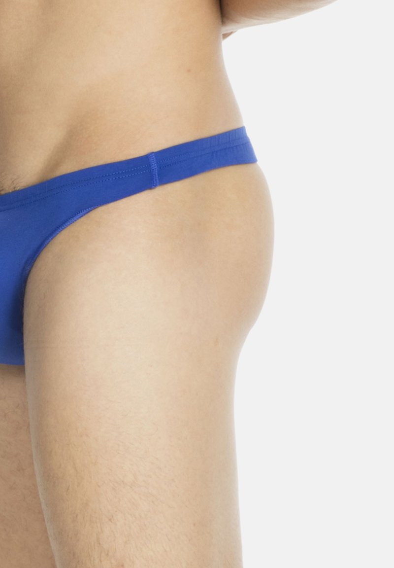 Blauer Baumwoll-Tanga mit schmalem Bund, glatter Textur und minimalistischen Design, der den unteren Rumpf und die Hüften bedeckt.