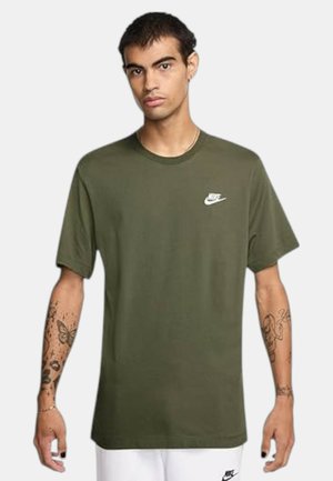 Camiseta de Nike color verde oliva con cuello redondo, mangas cortas y un logo de Nike blanco en el lado izquierdo del pecho. Tela de algodón suave, corte relajado.