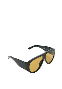 Lunettes de soleil noires avec un design angulaire, verres teintés jaunes et monture épaisse. Plastique léger avec une texture lisse.
