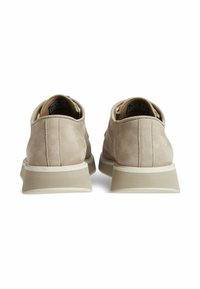 Scarpe in suede beige con design a bassa altezza, caratterizzate da una superficie testurizzata, dettagli di cucitura sottili e suola in gomma con un accento bianco.