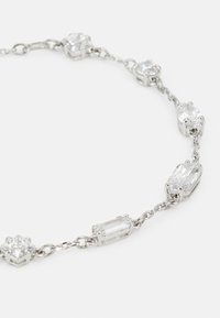 Collana in tonalità argento con cristalli trasparenti alternati a forma rettangolare e a goccia, uniti da una delicata catena. Finitura liscia.
