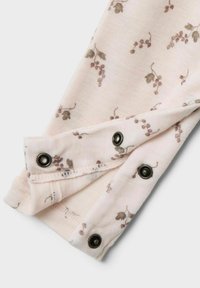 Tejido de un suave color rosa con un patrón floral en tonos apagados de verde y marrón, con cierres a presión negros en el puño para un ajuste seguro.