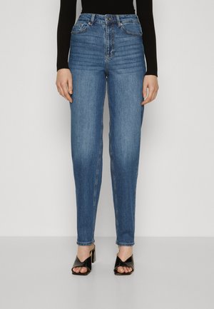 High-waisted blue jeans with a straight fit, made of denim. Features five pockets and stitched detailing, paired with black heeled sandals.
