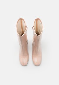 Rosa patentlæder ankelstøvler med en tætsiddende design, lodret lynlåslukning og runde tær. Glat tekstur og skinnende finish.