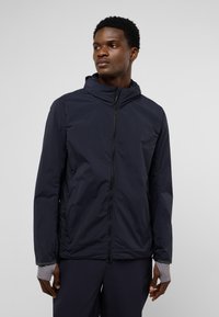 Marineblauer leichter Jacke mit Kapuze, durchgehendem Reißverschluss, seitlichen Taschen und elastischen Bündchen. Glatte Textur und minimalistisches Design.