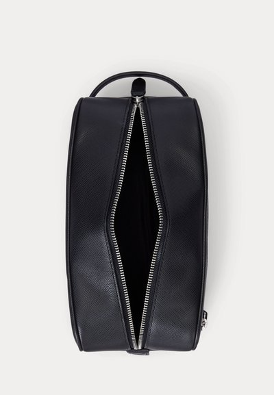 Μαύρο υφασμένο δερμάτινο νεσεσέρ με ασημένιο φερμουάρ μερικώς ανοιχτό, που δείχνει το άδειο εσωτερικό, και μια λαβή στην κορυφή.