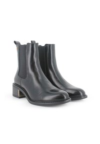 Botas Chelsea de cuero negro con paneles elásticos laterales, punteras redondeadas y un tacón bajo tipo bloque con un acento dorado. Textura suave y diseño elegante.