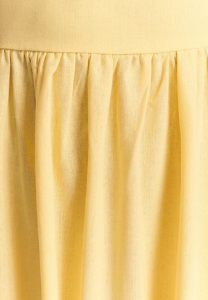 Gul stofnederdel med en tekstureret, letvægtsmateriale. Har et samlet design og en elastisk talje for en afslappet pasform.