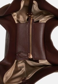 Borsa tote in pelle marrone con una finitura testurizzata. L'interno è foderato in raso e presenta una tasca con zip, chiusa da hardware dorato.