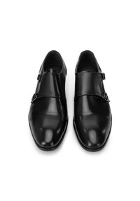 Schwarze Lederschuhe mit glänzender Oberfläche, die ein schlankes Design und doppelte Schnallenakzente über dem Mittelfuß aufweisen. Mandelförmige Zehen.