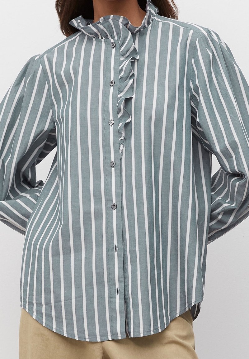 Camicia a righe in teal chiaro e bianco, con colletto arricciato e maniche lunghe con orlo curvo. Materiale in cotone testurizzato.