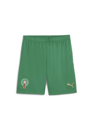 Zaļas sporta bikses, kas izgatavotas no viegla auduma, ar zelta Puma logo un apļa Marokas emblēmu uz kreisā kājas.