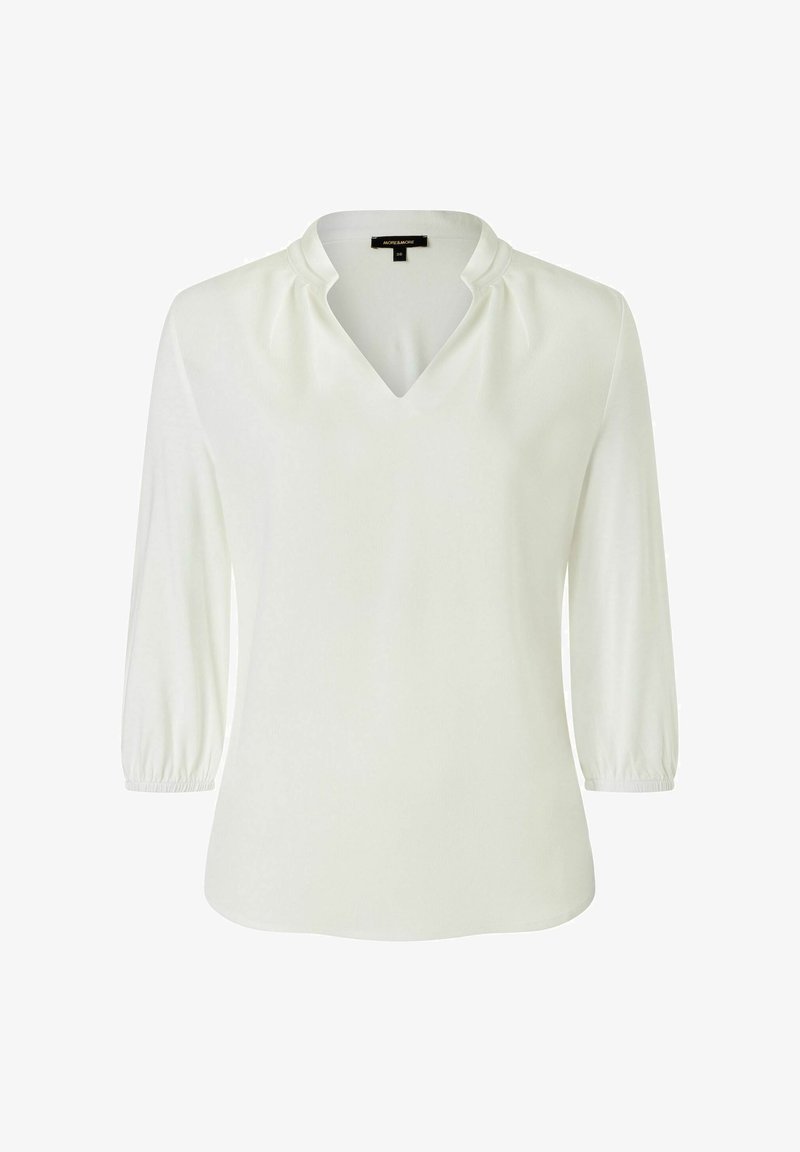 Witte blouse met een V-hals, driekwart mouwen en geplooide details op de schouders. Zachte textuur en licht gebogen zoom.