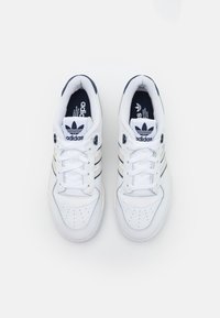 Vita läder sportskor med marinblå detaljer, med tre-stripes design, perforerad tåbox och runda snören. Logotyp på tungan.